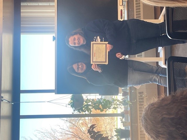 Amanda Moulton Standing with the Dean holding the work study student of the year award. 